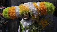 Para peserta pesta, yang dikenal sebagai sayones, mengenakan topi kertas tisu selama perayaan Paskah, di Tetela del Volcan, Meksiko, Minggu (20/4/2025).