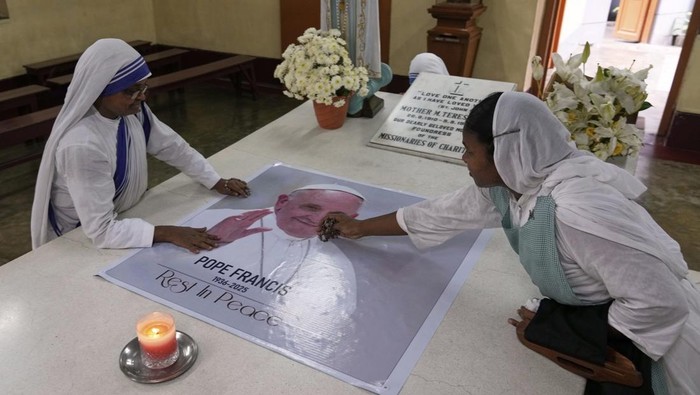 Doa untuk Paus Fransiskus di Makam Santa Teresa India A Catholic nun of the Missionaries of Charity, the order founded by Saint Teresa, prays as a portrait of Pope Francis is placed over the tomb following his death, in Kolkata, India, Tuesday, April 22, 2025. (AP Photo/Bikas Das)