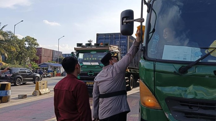 Kapolres Pelabuhan Tanjung Priok AKBP Martuasah Tobing membagikan sembako kepada para supir truk bongkar muat. Dia sekaligus mengimbau para sopir untuk tertiba mengantre.