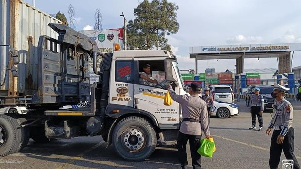 Kapolres Pelabuhan Tanjung Priok AKBP Martuasah Tobing membagikan sembako kepada para supir truk bongkar muat. Dia sekaligus mengimbau para sopir untuk tertiba mengantre.