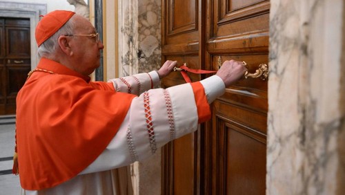 Cardinal Camerlengo Kevin Joseph Farrell seals the door to the papal bedroom and studio at the Vatican on Monday. Vatican Media/AP