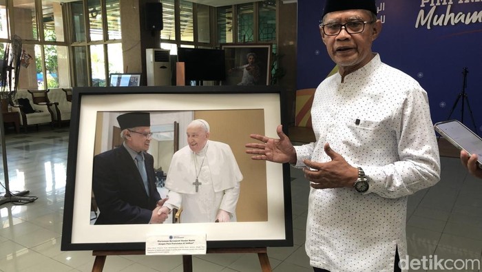 Ketum PP Muhammadiyah Haedar Nashir menunjukan fotonya bersama Paus Fransiskus di Kantor PP Muhammdiyah, Selasa (22/4/2025).