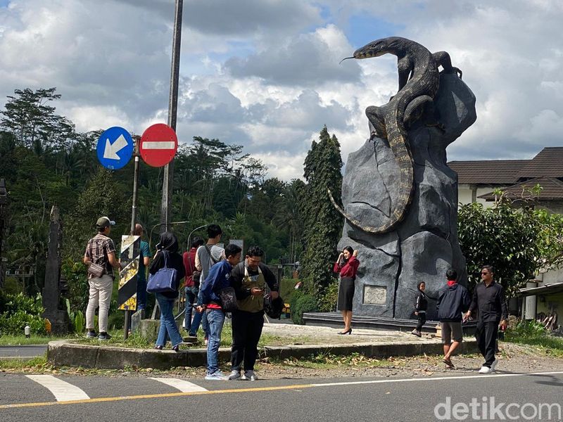 Warga yang melintas patung biawak menyempatkan berswafoto usai viral.