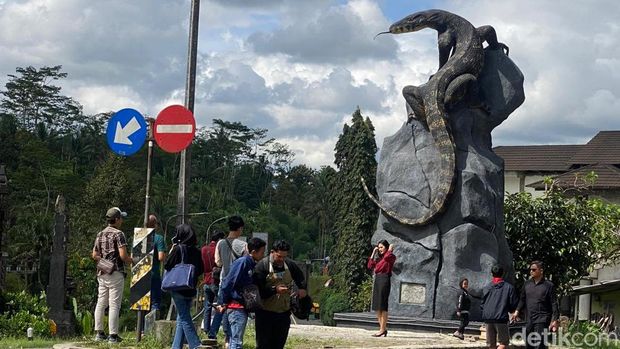 Warga yang melintas patung biawak menyempatkan berswafoto usai viral.