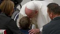 Paus Fransiskus mencium seorang anak di akhir audiensi umum mingguan, di Aula Paulus VI, Vatikan, Rabu, 18 Desember 2019. Massimo Valicchia/NurPhoto via Getty Images