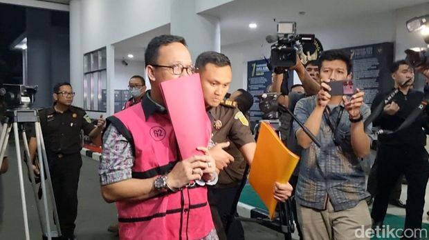 Tian Bahtiar (TB) (pakai masker) dan Junaedi Saibih (JS) (tutupi wajah dengan map)