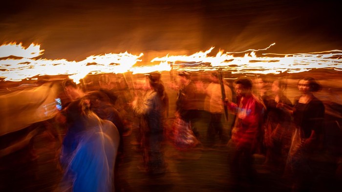 Warga membawa obor berjalan membentuk lingkaran saat tradisi Lamporan Jaringan Masyarakat Peduli Pegunungan Kendeng (JM-PPK) bertajuk Nyawiji Bumi di lereng Pegunungan Kendeng, Desa Gadudero, Kecamatan Sukolilo, Kabupaten Pati, Jawa Tengah, Senin (21/4/2025). Tradisi Lamporan sebagai simbol untuk mengusir malapetaka atau tolak bala hama pertanian dalam rangkaian memperingati Hari Kartini dan Hari Bumi yang diikuti ratusan warga perwakilan buruh, petani, peternak, perikanan, mahasiswa, santri, hingga seniman dari berbagai wilayah di Jateng  itu menyerukan tentang pelestarian alam di Indonesia, serta bentuk penolakan pada kebijakan yang merusak lingkungan. ANTARA FOTO/Aji Styawan/rwa.