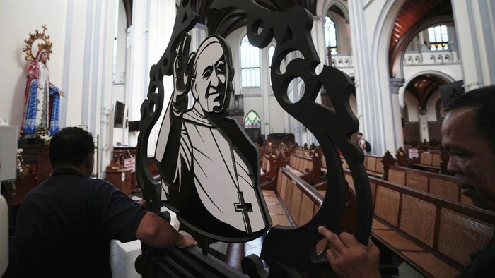 Umat Katolik di Dunia Meratapi Kepergian Paus Fransiskus Church workers prepare an ornament depicting Pope Francis ahead of a mass at the Cathedral of Our Lady of the Assumption, which was visited by Pope Francis in 2024, in Jakarta, Indonesia, Monday, April 21, 2025. (AP Photo/Achmad Ibrahim)