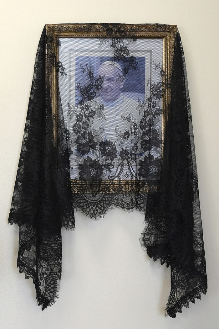 Umat Katolik di Dunia Meratapi Kepergian Paus Fransiskus A black veil is draped over a picture of Pope Francis displayed inside the offices of the Cathedral of St. Mary, Monday, April 21, 2025, in Miami. (AP Photo/Rebecca Blackwell)