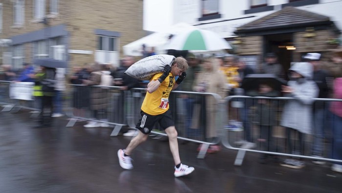 World Coal Carrying Puluhan peserta perempuan mengikuti lomba lari unik di Inggris. Mereka berlari memanggul batu bara sejauh 1,1 km dalam World Coal Carrying.