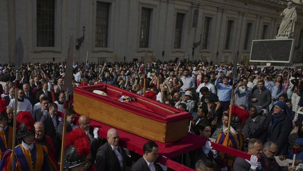 The body of Pope Francis is carried into St. Peter's Basilica at the Vatican, Wednesday, April 23, 2025, where he will lie in state for three days. (AP Photo/Emilio Morenatti)