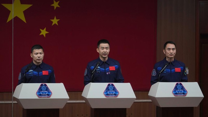 Journalists film Chinese astronauts for the upcoming Shenzhou 20 mission, from left, Wang Jie, captain Chen Dong and Chen Zhongrui wave at the Jiuquan Satellite Launch Center in northwest China, Wednesday, April 23, 2025. (AP Photo/Andy Wong)
