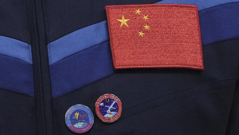 Journalists film Chinese astronauts for the upcoming Shenzhou 20 mission, from left, Wang Jie, captain Chen Dong and Chen Zhongrui wave at the Jiuquan Satellite Launch Center in northwest China, Wednesday, April 23, 2025. (AP Photo/Andy Wong)