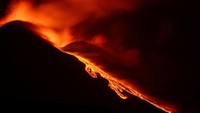 Lava panas mengalir dari Gunung Etna di Sisilia, Italia, Selasa (22/4/2025), dalam salah satu erupsi terbarunya yang terlihat jelas dari kejauhan.