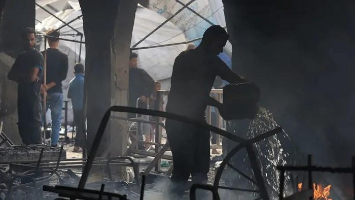 A Palestinian man extinguishes a fire at a school sheltering displaced people, following an Israeli strike, in Gaza City, April 23, 2025. (Reuters)