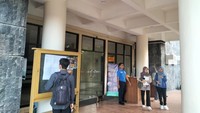 2. Salah satu petugas menyebut peserta yang baru datang harus mengisi daftar hadir terlebih dahulu. Foto: Novia Aisyah/detikEdu