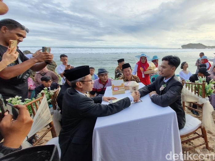 Suasana akad nikah dengan mahar kelapa muda di pinggir Pantai Sundak, Tepus, Gunungkidul, Rabu (23/4/2025).