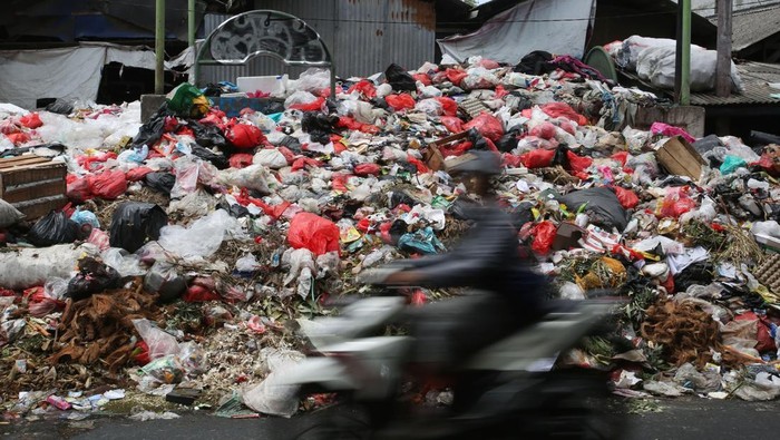 Pengendara motor melintas di depan tumpukan sampah yang menggunung yang ada di pinggir jalan raya Cimanggis, Ciputat, Tangerang Selatan, Banten, Rabu (23/4/2025). Tumpukan sampah yang menggunung terjadi akibat adanya kendala pengangkutan sampah ke tempat pembuangan akhir (TPA), sebelumnya Kejaksaan Negeri Prov Banten menetapkan Kepala Dinas Lingkungan Hidup Tangsel beserta staff sebagai tersangka kasus dugaan korupsi kegiatan jasa layanan pengangkutan dan pengelolaan sampah tahun anggaran 2024, dengan kerugian negara sebesar Rp75,94 miliar. ANTARA FOTO/Muhammad Iqbal/foc.