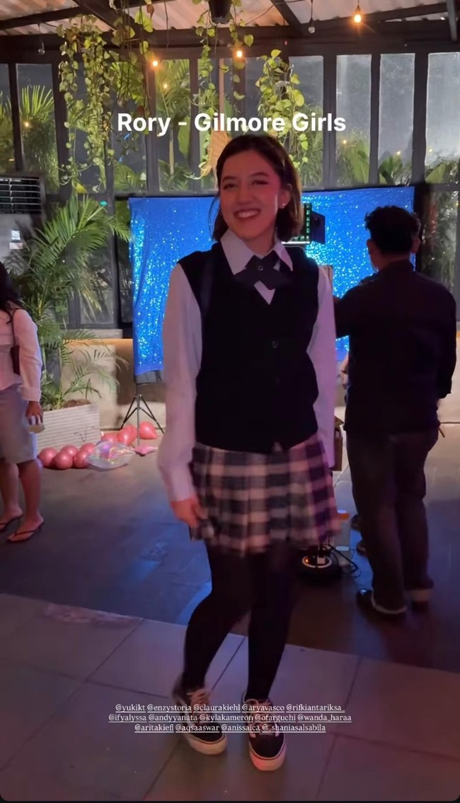 Ify Alyssa memilih bergaya mirip tokoh Rory di film Gilmore Girls. Ia memadukan kemeja putih lengan panjang dengan vest, dasi, rok kotak-kotak, dan stoking hitam. Foto: Instagram
