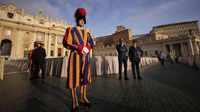 Pontifical Swiss guards stand in St. Peter's Square before the arrival of the body of Pope Francis, who will lie in state at St. Peter's Basilica for three days, at the Vatican, Wednesday, April 23, 2025. (AP Photo/Andreea Alexandru)