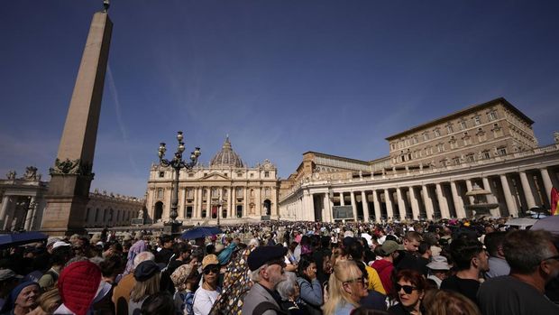 People wait in St. Peter's Square to pay their respect to the late Pope Francis, who will lie in state at St. Peter's Basilica for three days, at the Vatican, Wednesday, April 23, 2025. (AP Photo/Andreea Alexandru)