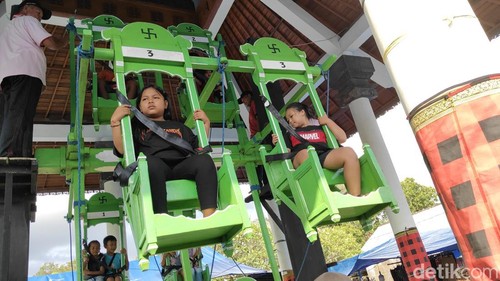 Keseruan anak-anak menaiki ayunan jantra di Mengwi, Badung, Kamis (24/4/2025).