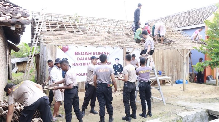 Aparat Kepolisian dari Polres Rembang saat gotong royong melakukan bedah rumah milik Sumarmi, warga Desa Turusgede, Rembang yang kondisi rumahnya sudah tidak layak ditinggali.