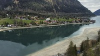 Pegunungan tercermin di permukaan Danau Walchensee yang surut akibat kekeringan ekstrem di Bavaria, Jerman, Selasa (22/4/2025). Danau terdalam dan terindah di Jerman ini mengalami penurunan permukaan air yang signifikan selama April 2025.    