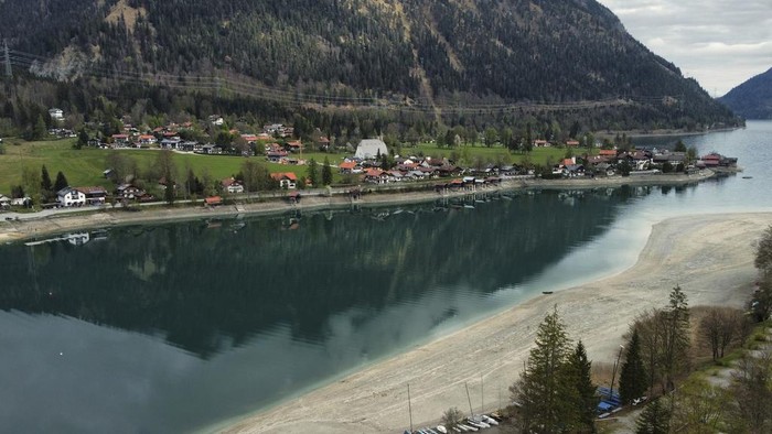 The mountains are reflected in the water of lake 'Walchensee' during low water near Garmisch-Partenkirchen, Germany, Tuesday, April 22, 2025. (AP Photo/Matthias Schrader)
