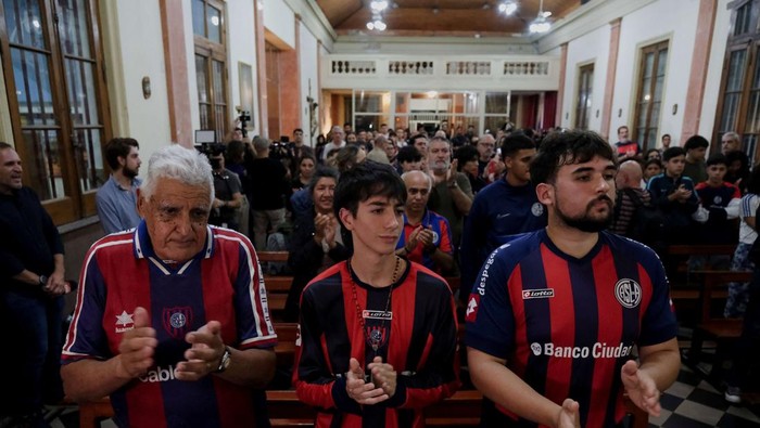 An artist draws a portrait of Pope Francis on the ground outside the venue where fans of San Lorenzo de Almagro, Pope Francis' hometown soccer team, participate in Mass as homage to him following his death, in Buenos Aires, Argentina, April 23, 2025. REUTERS/Alessia Maccioni