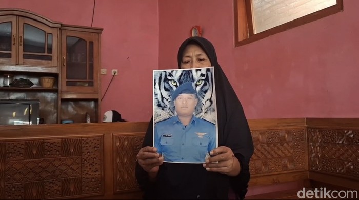 Ibunda Rizal Sampurna menunjukkan foto putranya saat memakai seragam sekolah pelayaran.