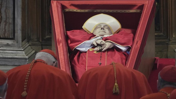 Cardinal Camerlengo Kevin Joseph Farrell asperges incense around the body of Pope Francis inside St. Peter's Basilica at the Vatican, Wednesday, April 23, 2025, where he will lie in state for three days. (AP Photo/Andrew Medichini, Pool)
