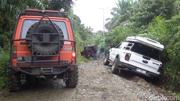 Mobil putih yang dikendarai Gubsu Bobby terperosok saat meninjau jalan rusak di Kabupaten Paluta (Foto: Nizar Aldi/detikSumut)