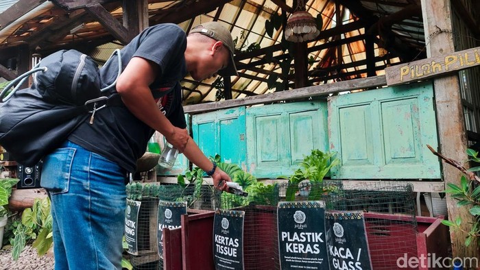Pelanggan membuang sampah ke wadah yang tersedia sesuai jenisnya