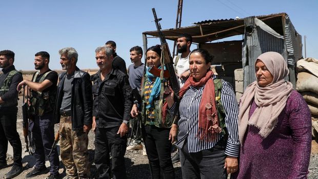 Wanita dan pria Kurdi menghadiri pelatihan tentang cara menggunakan senjata di Qamishli, Suriah, 18 April 2025. (REUTERS/Orhan Qereman)