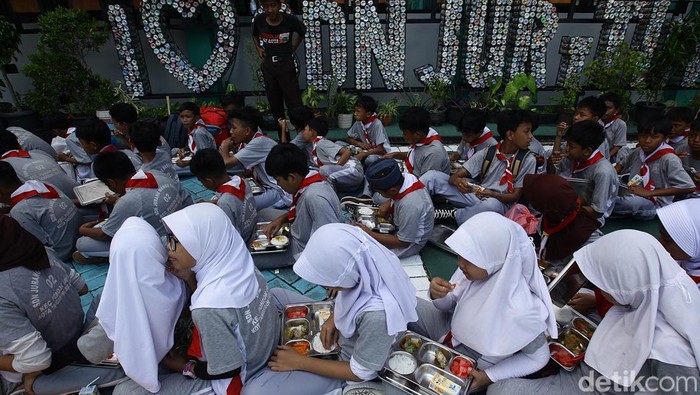 Murid SD menerima dan menyantap menu makan bergizi gratis di SDN Jurang Mangu Timur 02, Tangerang Selatan, Banten, Selasa (25/4/2025).