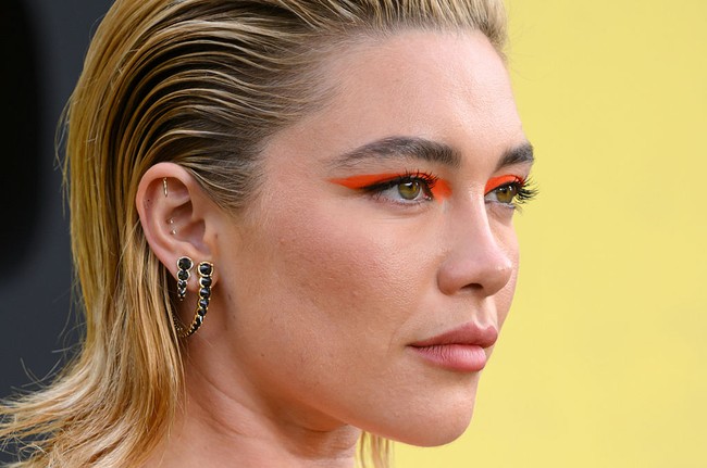 Penampilannya dilengkapi tatanan rambut sleek yang ditarik ke belakang dan riasan mata merah mencolok menyerupai topeng, memberi kesan futuristik ala pahlawan super. (Foto: Karwai Tang/WireImage)