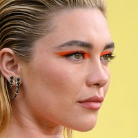 Penampilannya dilengkapi tatanan rambut sleek yang ditarik ke belakang dan riasan mata merah mencolok menyerupai topeng, memberi kesan futuristik ala pahlawan super. (Foto: Karwai Tang/WireImage)