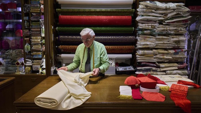 Penjahit Italia Mulai Siapkan Jubah Jelang Pemilihan Paus Baru Italian tailor Raniero Mancinelli, 87, and her daughter Laura Mancinelli, 60, prepare the white fabric to create suits, in three different sizes, to be taken to the Vatican in the hope that it might be worn by the new pope, at their shop in Rome, Thursday April 24, 2025. (AP Photo/Bernat Armangue)