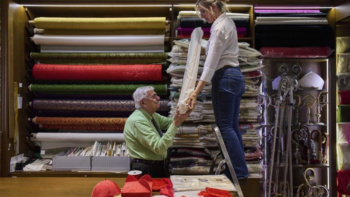 Penjahit Italia Mulai Siapkan Jubah Jelang Pemilihan Paus Baru Italian tailor Raniero Mancinelli, 87, and her daughter Laura Mancinelli, 60, prepare the white fabric to create suits, in three different sizes, to be taken to the Vatican in the hope that it might be worn by the new pope, at their shop in Rome, Thursday April 24, 2025. (AP Photo/Bernat Armangue)