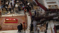 Suasana haru menyelimuti prosesi penghormatan, dengan lonceng berdentang selama 40 menit saat peti jenazah dibawa ke altar utama oleh para kardinal dan imam. Banyak pelayat yang rela menunggu berjam-jam di bawah terik matahari musim semi demi memberikan penghormatan terakhir kepada pemimpin Gereja Katolik Roma tersebut. AP/Gregorio Borgia