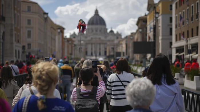 Ribuan Orang Berikan Penghormatan Terakhir untuk Paus Fransiskus People walk along Via della Conciliazione avenue to line up to view Pope Francis lying in state inside St. Peter's Basilica, seen in the background, at the Vatican, Thursday, April 24, 2025. (AP Photo/Andrew Medichini)