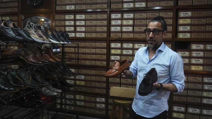 Toko Sepatu Ini Simpan Jejak Kesederhanaan Paus Fransiskus A photograph of the late Pope Francis sits in the window of the Muglia shoe store alongside the model of shoes that Jorge Bergoglio used in the Flores neighborhood where he grew up in Buenos Aires, Argentina, Thursday, April 24, 2025. (AP Photo/Natacha Pisarenko)
