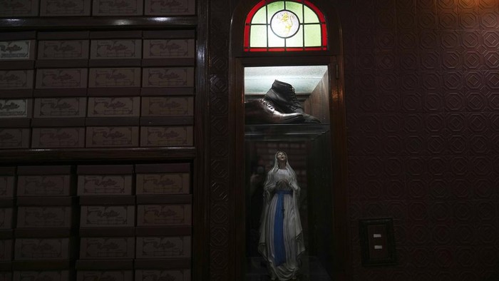 A photograph of the late Pope Francis sits in the window of the Muglia shoe store alongside the model of shoes that Jorge Bergoglio used in the Flores neighborhood where he grew up in Buenos Aires, Argentina, Thursday, April 24, 2025. (AP Photo/Natacha Pisarenko)