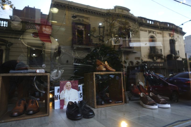 Toko Sepatu Ini Simpan Jejak Kesederhanaan Paus Fransiskus A photograph of the late Pope Francis sits in the window of the Muglia shoe store alongside the model of shoes that Jorge Bergoglio used in the Flores neighborhood where he grew up in Buenos Aires, Argentina, Thursday, April 24, 2025. (AP Photo/Natacha Pisarenko)