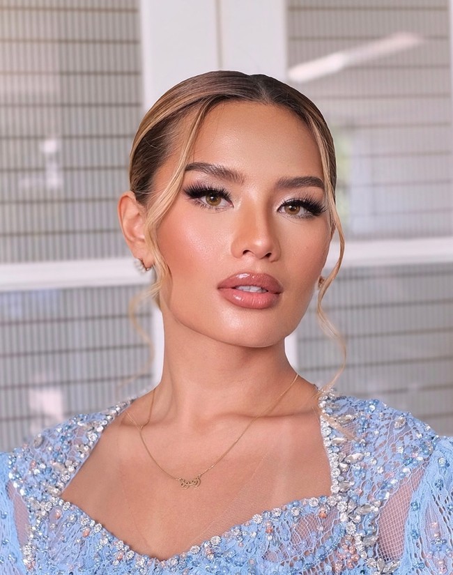 Bagian matanya terlihat menonjol dengan bulu mata palsu yang cukup tebal, dipercantik pulasan eyeshadow warna kecoklatan dan putih. Bibirnya terlihat penuh dengan teknik overline. Mempertahankan riasan soft-nya, Zahwa memiilih lipstik glossy berwarna nude. Foto: Instagram/@deanmua_