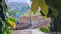 Pekerja menggunakan alat berat mengeruk lumpur endapan Kali Ciliwung di Jalan Inspeksi Ciliwung, kawasan Menteng, Jakarta, Sabtu (12/8/2024).