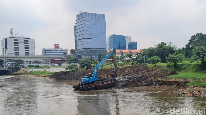Kali Ciliwung, Jalan Inspeksi Ciliwung, kawasan Menteng, Jakarta dikeruk. Dengan alat berat petugas membersihkan lumpur untuk antisipasi pendangkalan dan banjir.