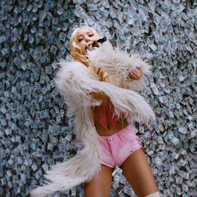 Selaras dengan makna di balik lagu Rapunzel, video live performance Lisa BLACKPINK menyorot penampilannya di sebuah studio berhamburan uang dollar. Lisa menyiratkan bagaimana kesuksesan mengantarkannya pada kehidupan mewah. Foto: dok. YouTube LLOUD