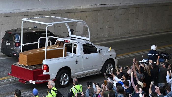 Peti mayat Paus Fransiskus dibawa dengan popemobile dari Vatikan menuju ke Basilika Santa Maria Maggiore di Roma untuk dimakamkan People gather along the road as the coffin of late Pope Francis is transported from St Peters Basilica to Santa Maria Maggiore Basilica, during the funeral ceremony in Rome on April 26, 2025. (Photo by Andrej ISAKOVIC / AFP)